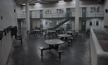 Movie still from “The Card Counter” (2021), directed by Paul Schrader – A room with many tables and chairs in it; Extreme Wide shot, High angle