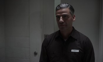 Movie still from “The Card Counter” (2021), directed by Paul Schrader – A man in a black shirt is standing in a room; Close Up shot, Over the shoulder angle