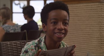 Movie still from “The Christmas Chronicles: Part Two” (2020), directed by Chris Columbus – A young boy holding a newspaper in his hands; Close Up shot, Over the shoulder angle