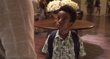 Movie still from “The Christmas Chronicles: Part Two” (2020), directed by Chris Columbus – A young boy wearing a backpack looking up at a table; Close Up shot, Over the shoulder angle