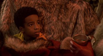 Movie still from “The Christmas Chronicles: Part Two” (2020), directed by Chris Columbus – A young boy laying on the couch looking at a cell phone; Close Up shot, High angle