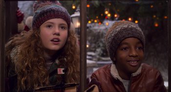Movie still from “The Christmas Chronicles: Part Two” (2020), directed by Chris Columbus – Two young people are standing next to each other in front of a christmas tree; Close Up shot, Over the shoulder angle