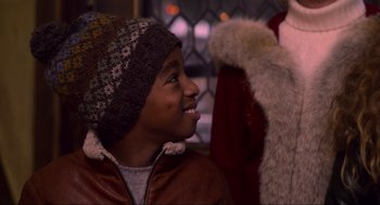 Movie still from “The Christmas Chronicles: Part Two” (2020), directed by Chris Columbus – A young boy wearing a winter hat and jacket; Close Up shot, Over the shoulder angle