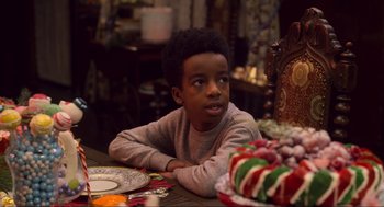 Movie still from “The Christmas Chronicles: Part Two” (2020), directed by Chris Columbus – A young boy sitting at a table with a cake; Close Up shot, Over the shoulder angle