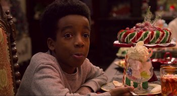 Movie still from “The Christmas Chronicles: Part Two” (2020), directed by Chris Columbus – A boy sitting at a table with a plate of candy; Close Up shot, Over the shoulder angle