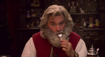 Movie still from “The Christmas Chronicles: Part Two” (2020), directed by Chris Columbus – A man with a long beard is holding a fork in his mouth; Close Up shot, Over the shoulder angle