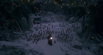Movie still from “The Christmas Chronicles: Part Two” (2020), directed by Chris Columbus – An image of a man in the snow with a light in his hand; Extreme Wide shot, High angle