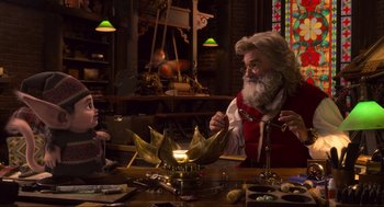 Movie still from “The Christmas Chronicles: Part Two” (2020), directed by Chris Columbus – A man dressed as santa claus lighting a candle; Medium shot, Over the shoulder angle