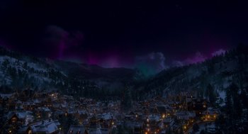 Movie still from “The Christmas Chronicles: Part Two” (2020), directed by Chris Columbus – A view of a city at night with the lights of a christmas tree in front of it; Extreme Wide shot, High angle