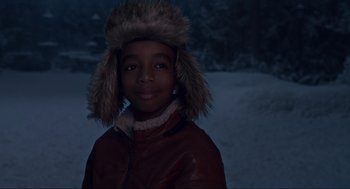 Movie still from “The Christmas Chronicles: Part Two” (2020), directed by Chris Columbus – A young boy wearing a brown jacket and a fur hat; Close Up shot, High angle