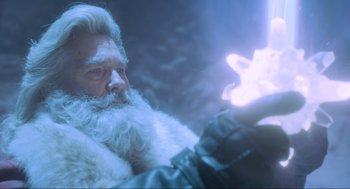 Movie still from “The Christmas Chronicles: Part Two” (2020), directed by Chris Columbus – An old man with a long white beard holding a glowing object; Close Up shot, Low angle
