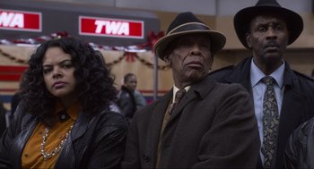 Movie still from “The Christmas Chronicles: Part Two” (2020), directed by Chris Columbus – An older man wearing a suit and a hat; Medium shot, Low angle