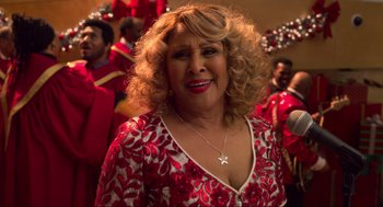 Movie still from “The Christmas Chronicles: Part Two” (2020), directed by Chris Columbus – A person wearing a red and white dress; Close Up shot, High angle