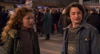 Movie still from “The Christmas Chronicles: Part Two” (2020), directed by Chris Columbus – Two people standing next to each other in a crowd of onlookers; Medium shot, Over the shoulder angle