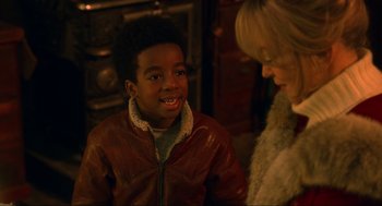 Movie still from “The Christmas Chronicles: Part Two” (2020), directed by Chris Columbus – A young boy wearing a red leather jacket talking to an older woman; Close Up shot, Over the shoulder angle