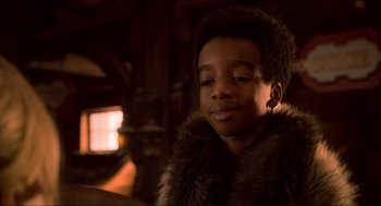 Movie still from “The Christmas Chronicles: Part Two” (2020), directed by Chris Columbus – A young boy wearing a fur coat looking at the camera; Close Up shot, Over the shoulder angle