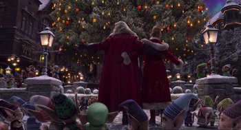 Movie still from “The Christmas Chronicles: Part Two” (2020), directed by Chris Columbus – Two women in red coats standing in front of a christmas tree; Wide shot, High angle