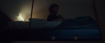 Movie still from “The Claus Family 3” (2022), directed by Ruben Vandenborre – A woman sitting on top of a bed in a dark room; Close Up shot, Low angle