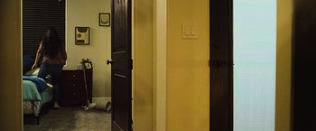 Movie still from “The Commando” (2022), directed by Asif Akbar – A room that has two doors open to a bathroom; Wide shot, Low angle