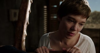 Movie still from “Crimes of the Future” (2022), directed by David Cronenberg – A young man sitting on a chair in a room; Close Up shot, High angle