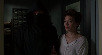 Movie still from “Crimes of the Future” (2022), directed by David Cronenberg – A woman standing next to a man wearing a black robe; Medium shot, Low angle