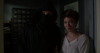 Movie still from “Crimes of the Future” (2022), directed by David Cronenberg – A man and a woman standing next to each other in a dark room; Close Up shot, Over the shoulder angle