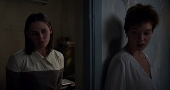 Movie still from “Crimes of the Future” (2022), directed by David Cronenberg – A woman standing next to a man in front of a door; Medium shot, Over the shoulder angle
