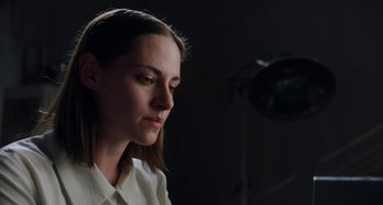 Movie still from “Crimes of the Future” (2022), directed by David Cronenberg – A woman in a white shirt is looking down; Close Up shot, Low angle