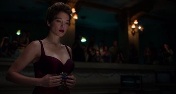 Movie still from “Crimes of the Future” (2022), directed by David Cronenberg – A woman in a red dress is holding a camera; Medium shot, Low angle