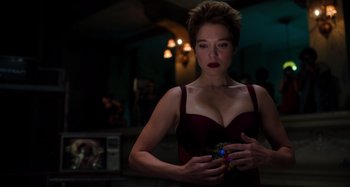 Movie still from “Crimes of the Future” (2022), directed by David Cronenberg – A beautiful woman in a red dress holding something in her hand; Medium shot, Low angle