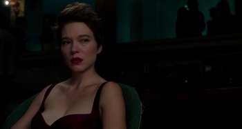 Movie still from “Crimes of the Future” (2022), directed by David Cronenberg – A woman with short brown hair wearing a red dress; Close Up shot, Over the shoulder angle