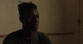 Movie still from “Crimes of the Future” (2022), directed by David Cronenberg – A person wearing a black shirt; Close Up shot, Over the shoulder angle