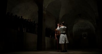 Movie still from “Crimes of the Future” (2022), directed by David Cronenberg – A man and a woman are standing in an old building; Extreme Wide shot, Low angle