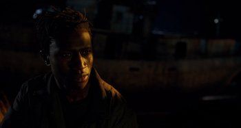 Movie still from “Crimes of the Future” (2022), directed by David Cronenberg – A young man is looking into the camera; Close Up shot, Low angle