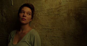 Movie still from “Crimes of the Future” (2022), directed by David Cronenberg – A woman standing in front of a brick wall; Close Up shot, Low angle