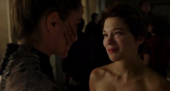 Movie still from “Crimes of the Future” (2022), directed by David Cronenberg – A woman looking at another woman in a dark room; Close Up shot, Over the shoulder angle