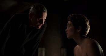 Movie still from “Crimes of the Future” (2022), directed by David Cronenberg – A man and a woman facing each other in a dark room; Close Up shot, Over the shoulder angle