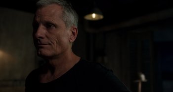 Movie still from “Crimes of the Future” (2022), directed by David Cronenberg – An older man is looking into the distance; Close Up shot, Over the shoulder angle