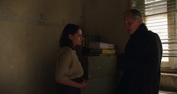 Movie still from “Crimes of the Future” (2022), directed by David Cronenberg – A man and a woman standing next to each other in a room; Medium shot, Over the shoulder angle