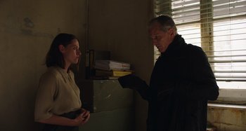 Movie still from “Crimes of the Future” (2022), directed by David Cronenberg – A man and a woman are standing in a room; Medium shot, Over the shoulder angle
