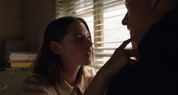Movie still from “Crimes of the Future” (2022), directed by David Cronenberg – A young woman touching a man's face with her hand; Close Up shot, Low angle
