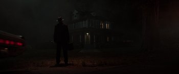 Movie still from “The Conjuring: The Devil Made Me Do It” (2021), directed by Michael Chaves – A man standing in front of a house in the dark; Wide shot, Low angle