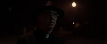 Movie still from “The Conjuring: The Devil Made Me Do It” (2021), directed by Michael Chaves – A man wearing a hat and glasses in the dark; Close Up shot, Low angle