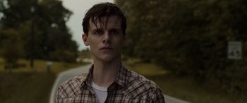 Movie still from “The Conjuring: The Devil Made Me Do It” (2021), directed by Michael Chaves – A man with wet hair standing on the side of a road; Close Up shot, Over the shoulder angle