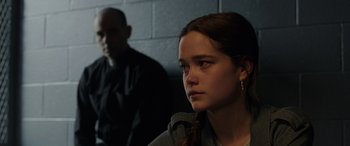 Movie still from “The Conjuring: The Devil Made Me Do It” (2021), directed by Michael Chaves – A young girl sitting in front of a brick wall; Close Up shot, Over the shoulder angle