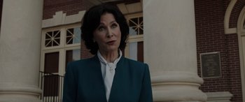 Movie still from “The Conjuring: The Devil Made Me Do It” (2021), directed by Michael Chaves – A woman wearing a suit and a white shirt; Close Up shot, Low angle
