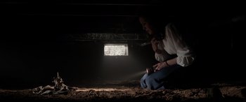 Movie still from “The Conjuring: The Devil Made Me Do It” (2021), directed by Michael Chaves – A woman sitting on the ground in a dark room; Medium shot, Low angle
