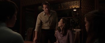 Movie still from “The Conjuring: The Devil Made Me Do It” (2021), directed by Michael Chaves – A man and a woman are standing in front of a table; Medium shot, Over the shoulder angle