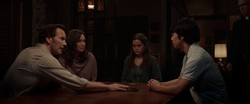 Movie still from “The Conjuring: The Devil Made Me Do It” (2021), directed by Michael Chaves – A group of people sitting around a table; Medium shot, Over the shoulder angle