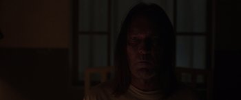 Movie still from “The Conjuring: The Devil Made Me Do It” (2021), directed by Michael Chaves – A man with long black hair is in the dark; Close Up shot, Low angle